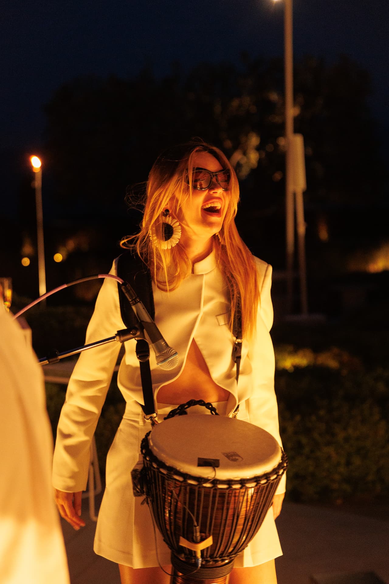 Percussionist laughing with her djembe under evening lights at Amanzoe